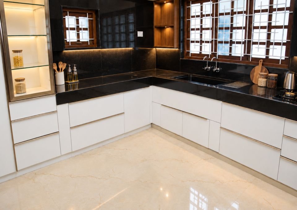 L-shaped kitchen with white drawers and black counter