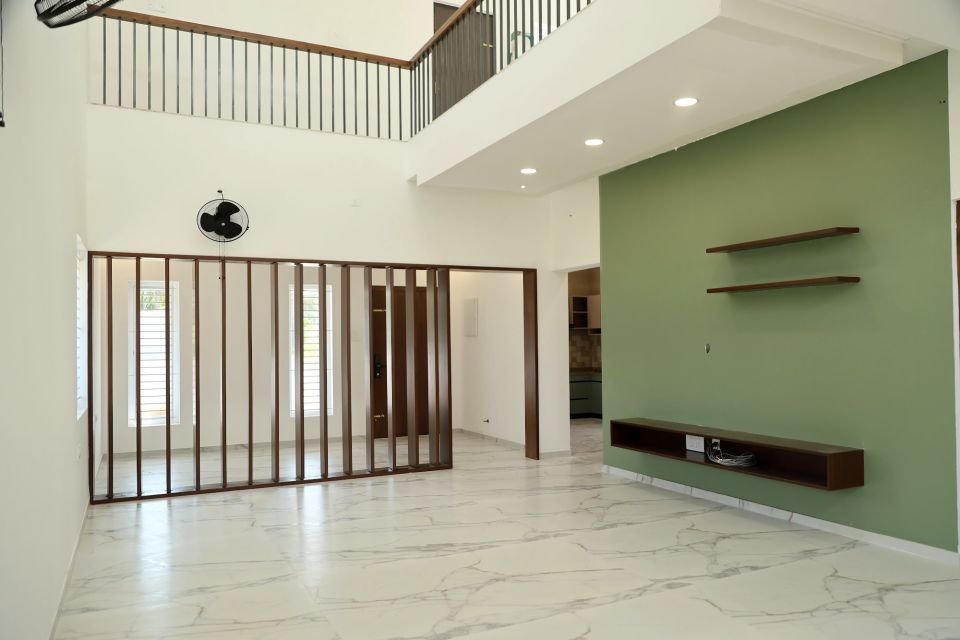 Double-height living room with a green TV wall