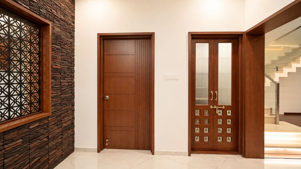 Stone clad wall with jali panel and wooden doors