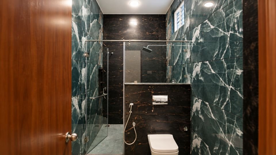 Bathroom with dark green marble finish tiles
